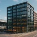 Representatief kantoor naast een treinstation met moderne gevel, warme ontvangsthal, veel daglicht en flexibele werkruimtes in een stedelijke omgeving.